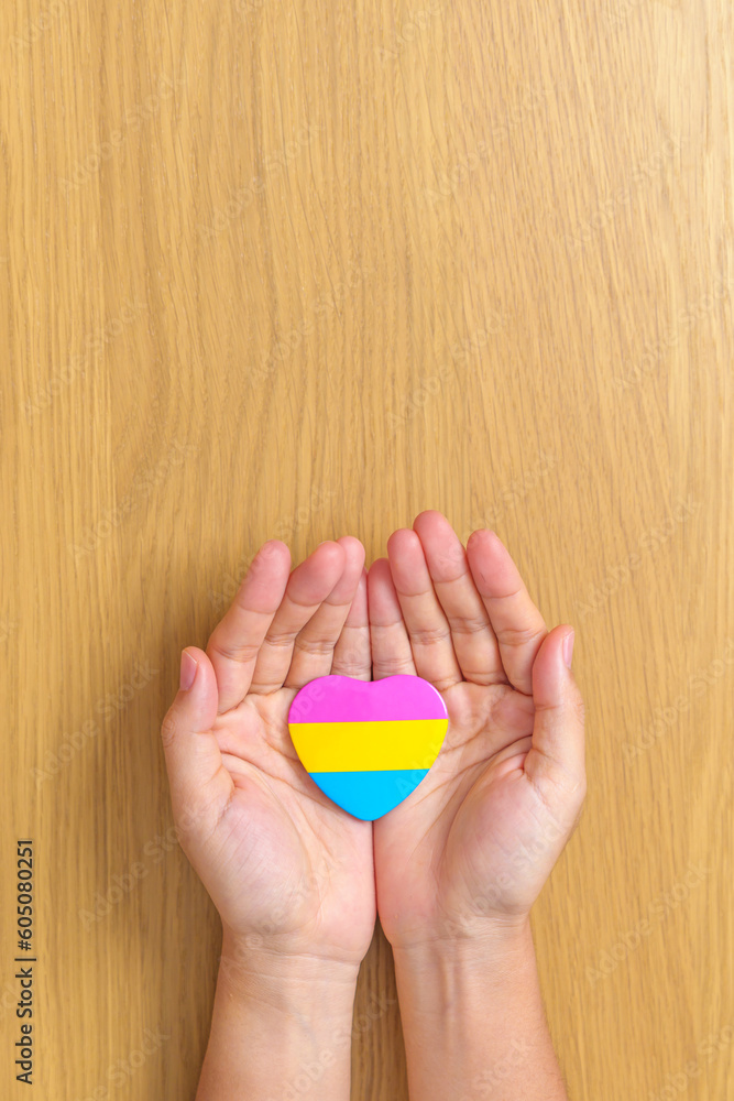 Pansexual Pride Day and LGBT pride month concept. hand holding pink, yellow and blue heart shape for Lesbian, Gay, Bisexual, Transgender, Queer and Pansexual community Pansexual Pride Day and LGBT pride month concept. hand holding pink, yellow and blue heart shape for Lesbian, Gay, Bisexual, Transgender, Queer and Pansexual community