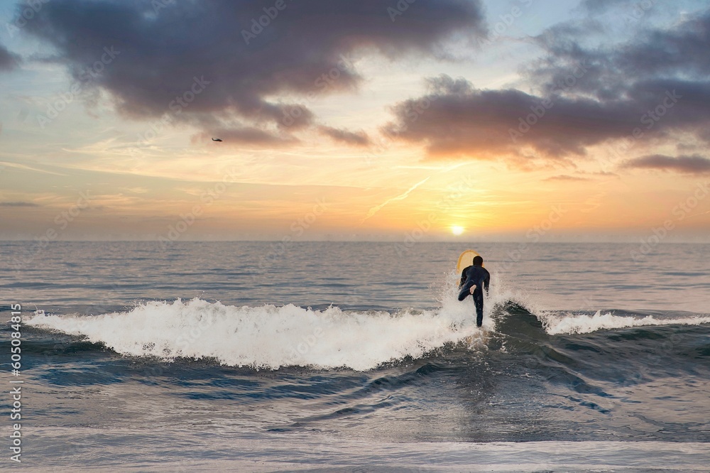  A surfer rides a wave at sunset 