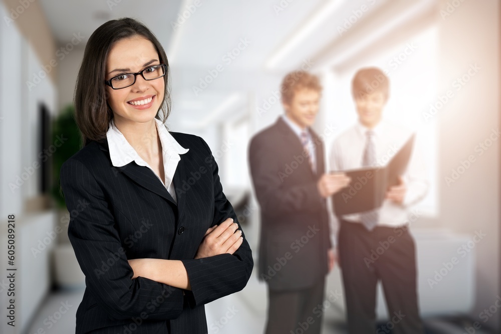 Successful young businesswoman standing in office and posing Successful young businesswoman standing in office and posing