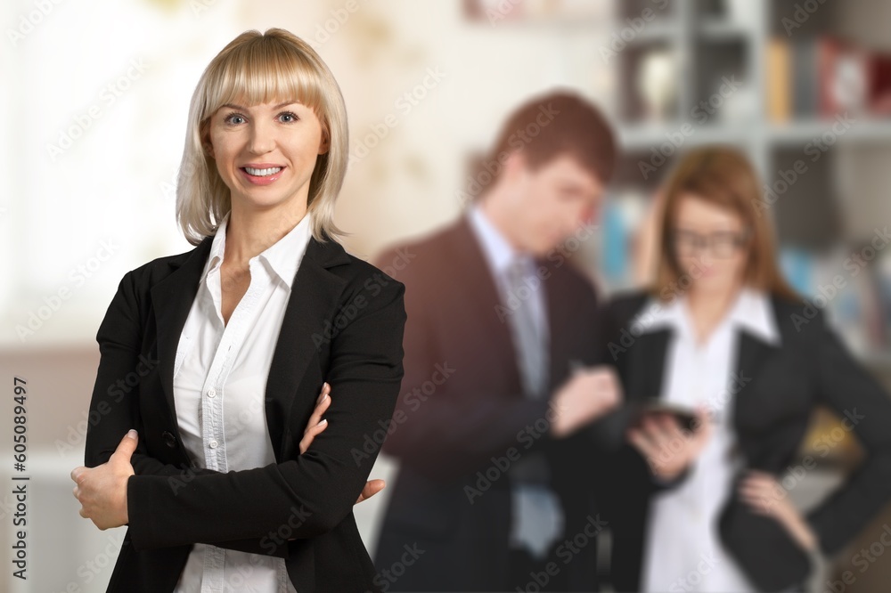 Successful young businesswoman standing in office and posing Successful young businesswoman standing in office and posing