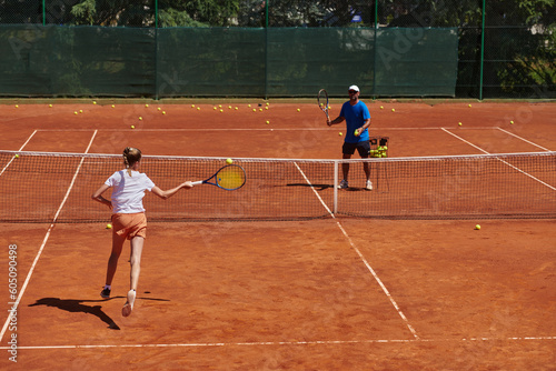 A professional tennis player and her coach training on a sunny day at the tennis court. Training and preparation of a professional tennis player