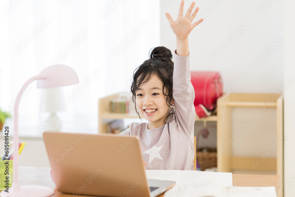 自宅でパソコンを見ながら勉強する女の子