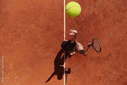 Top view of a professional female tennis player serves the tennis ball on the court with precision and power © .shock