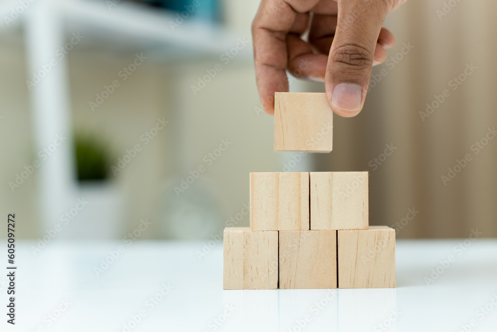 concept of grow success. hand holding and stacking wooden block cube step of business growth success. concept of grow success. hand holding and stacking wooden block cube step of business growth success.