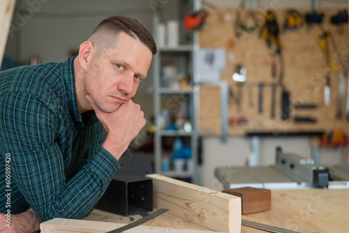 Portrait of a pensive caucasian man in a workshop. 