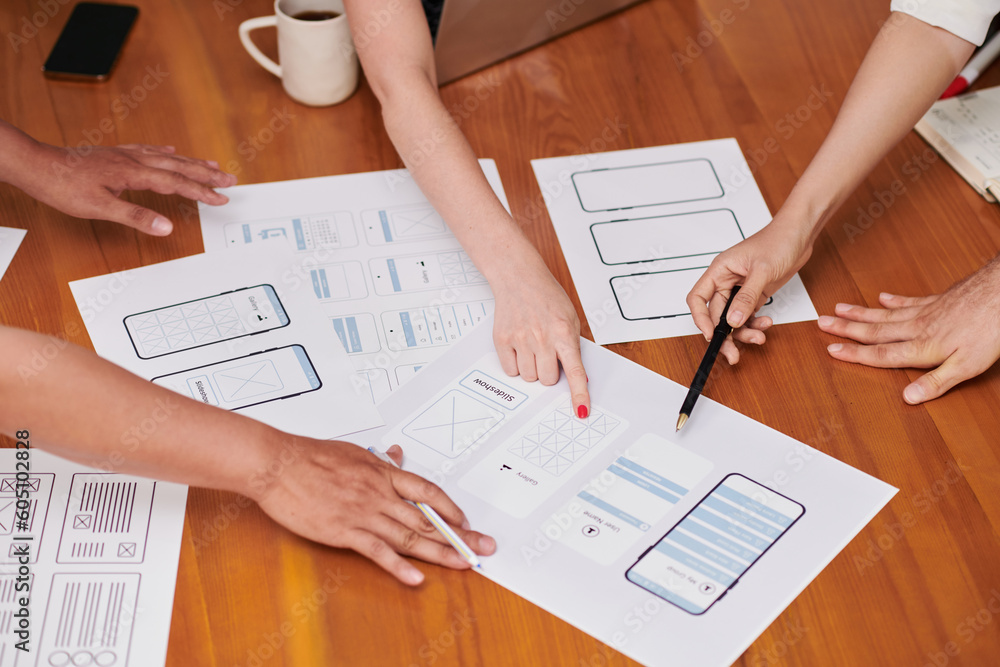 Closeup image of project manager and ui and ux designers discussing ideas for new interface Closeup image of project manager and ui and ux designers discussing ideas for new interface