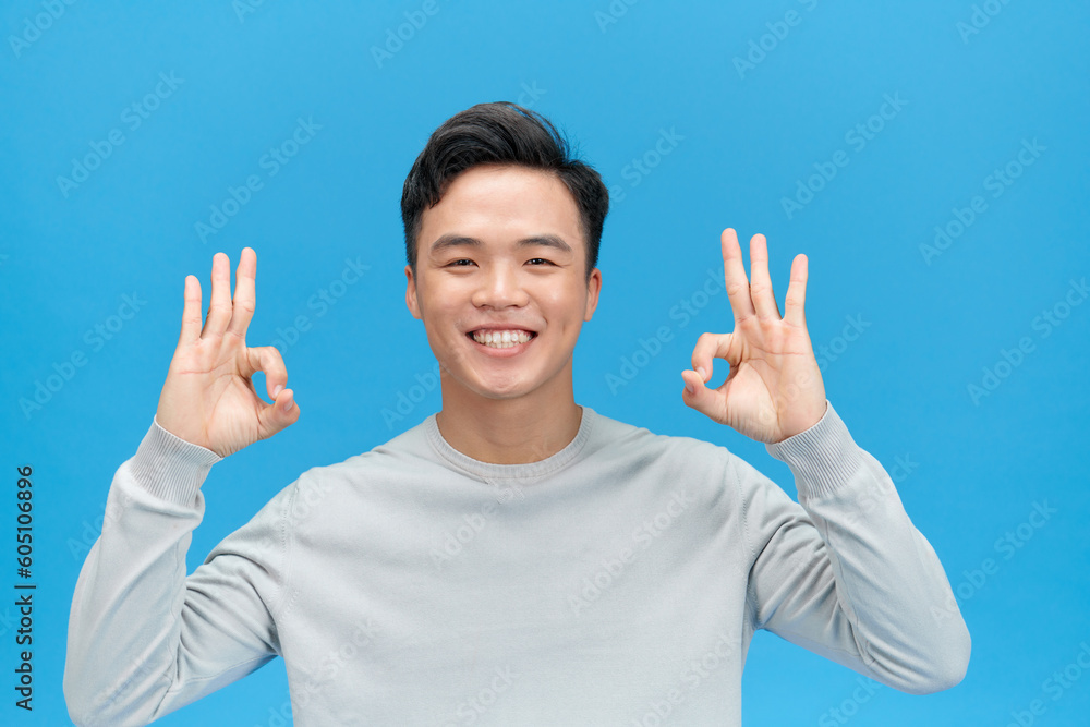 Portrait of handsome excited man in basic clothing smiling and showing ok sign at camera Portrait of handsome excited man in basic clothing smiling and showing ok sign at camera