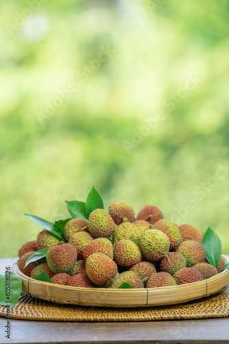 Chinese Green Lychee Bamboo basket  Green Lychee or Chinese Cherry fruit under sunlight on blurred nature background.