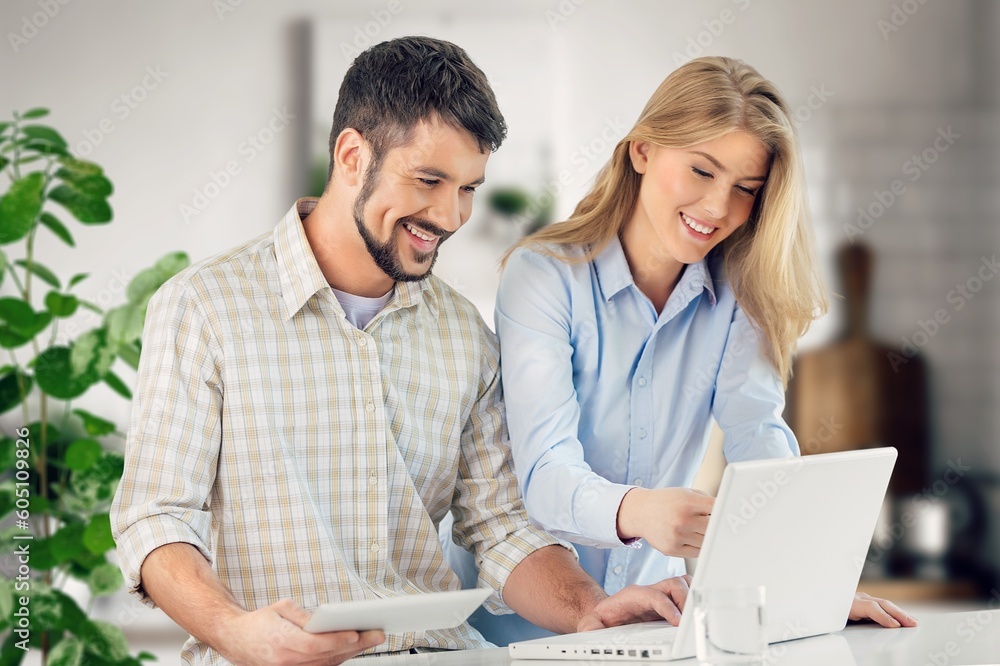 Two cheerful office workers work with laptop, Two cheerful office workers work with laptop,