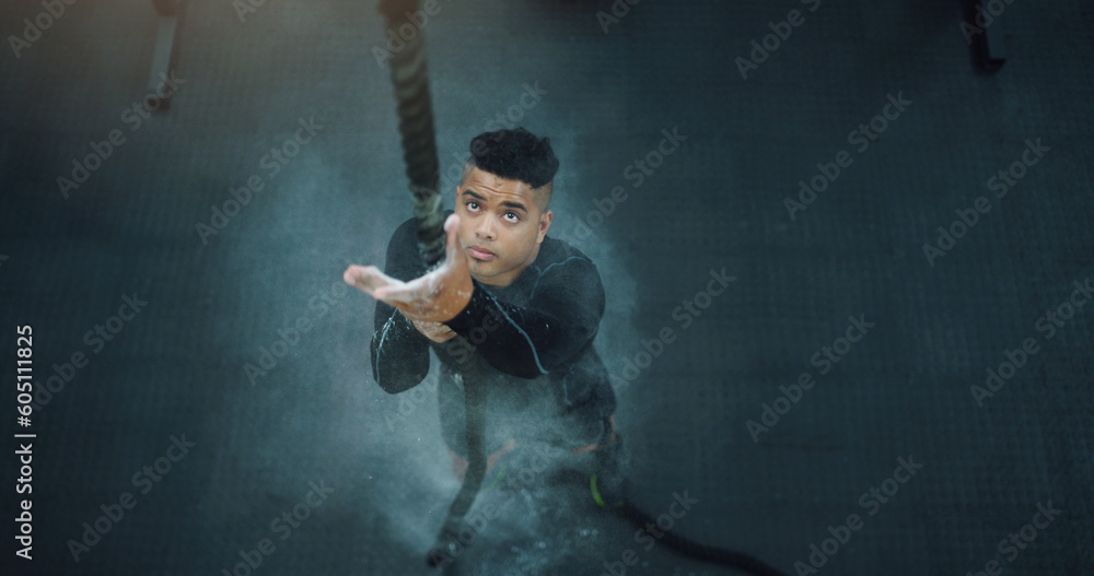 Rope climbing, fitness and man at gym from above for training ...