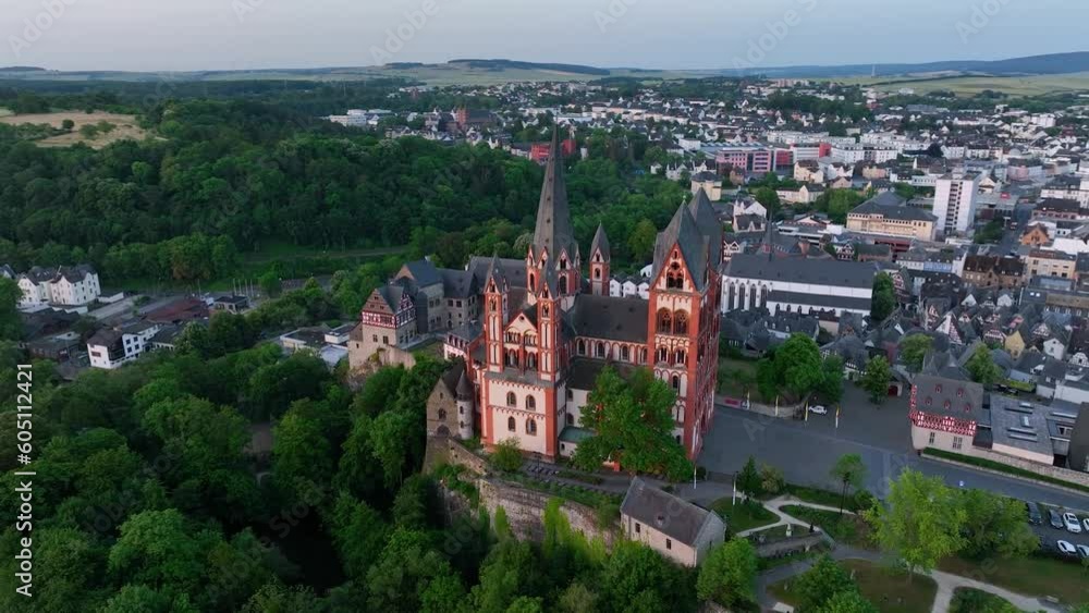 The camera circles around the tower of Historic tourist attraction Limburg Cathedral beside Lahn River, Hesse Germany. Aerial shot. Germany, Europe from above