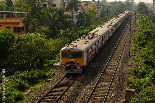 9th April, 2023, Kolkata, West Bengal, India: A local electric train on railway track of local train of Sealdah south main line in a bright day light with blue sky.
