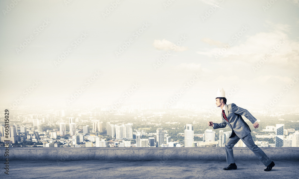 King businessman in elegant suit running on building roof and business center at background King businessman in elegant suit running on building roof and business center at background