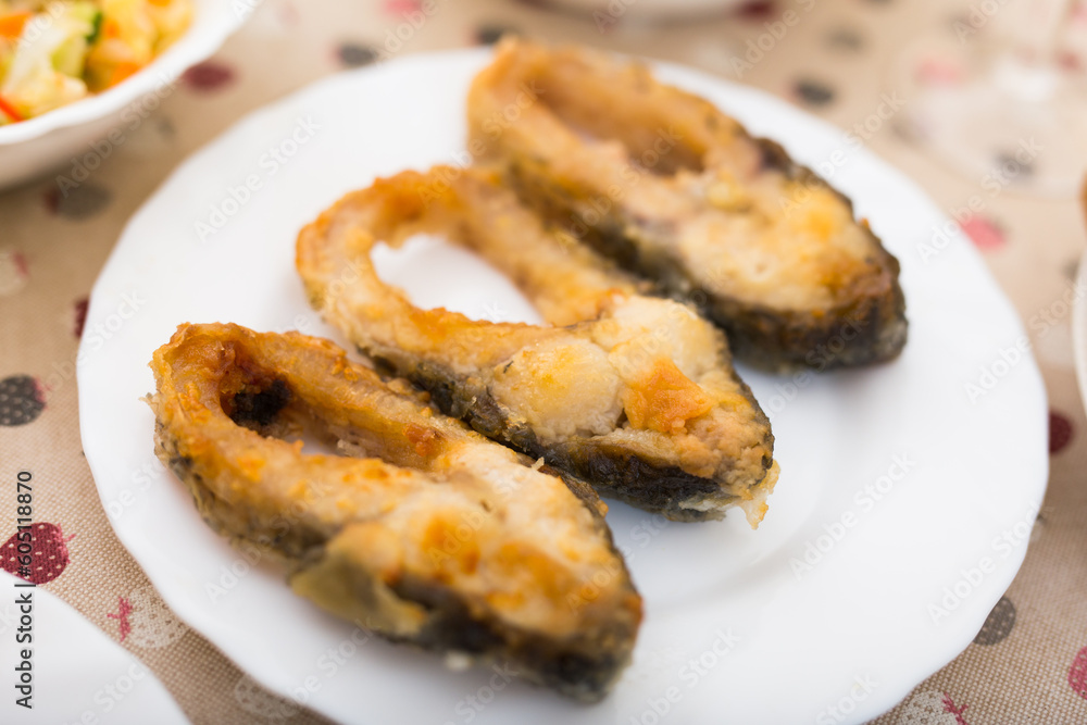 pieces of the middle part of the carp baked on a white plate