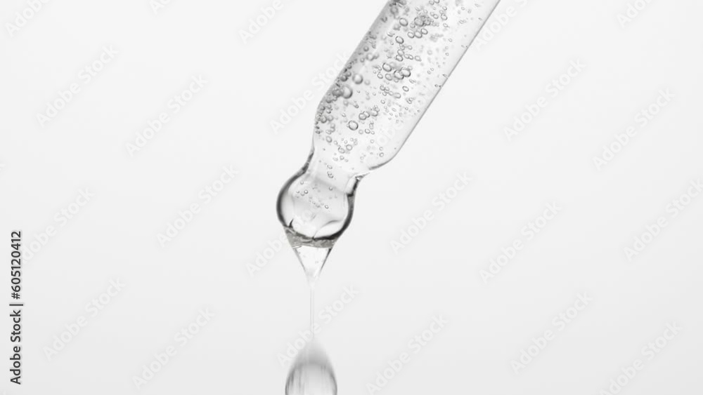 Closeup cosmetic serum fluid gel with bubbles from dropper, pipette over white Closeup cosmetic serum fluid gel with bubbles from dropper, pipette over white