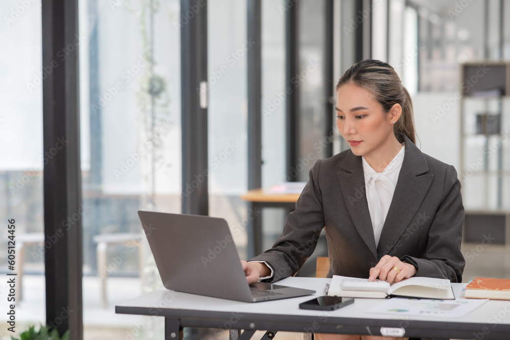 Young Asian businesswoman working on documents at office Young Asian businesswoman working on documents at office