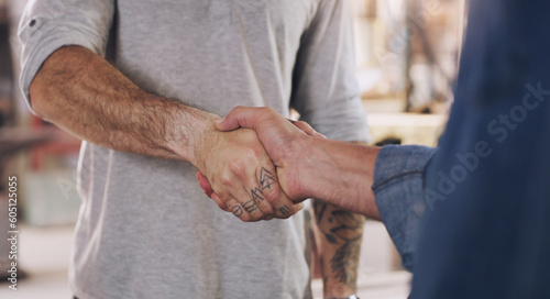 Handshake, welcome and partnership with men in a workshop together for a deal or agreement. Teamwork, meeting and greeting with male industry people shaking hands in a factory to gesture thank you