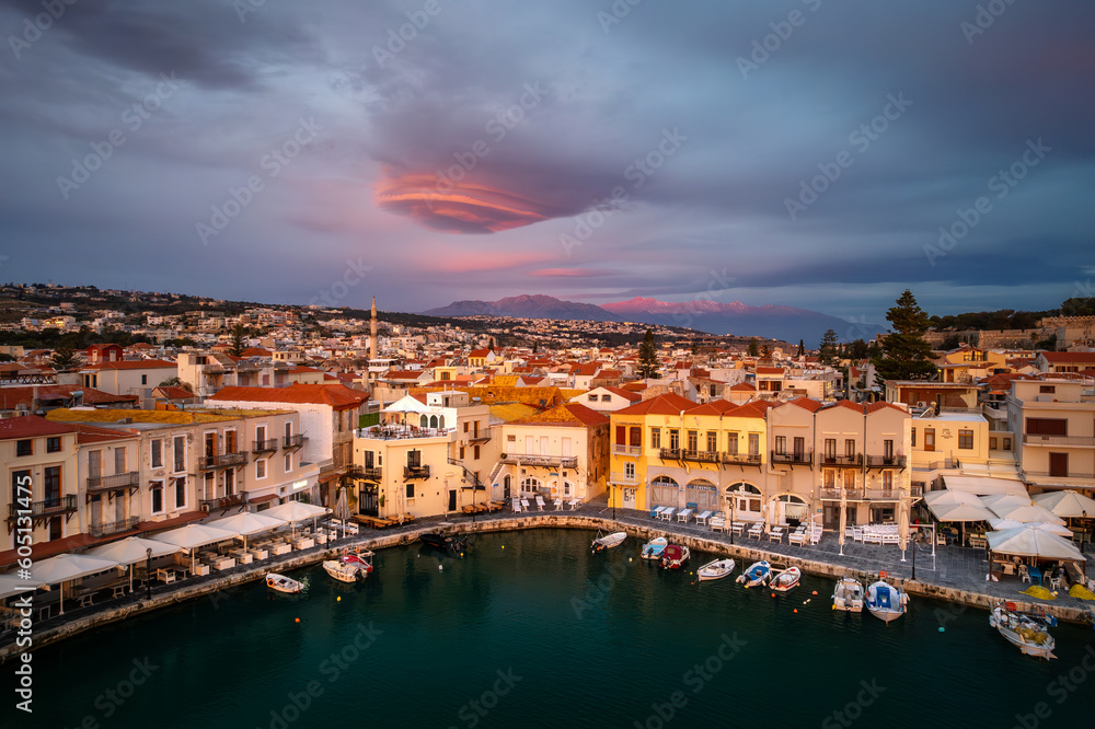 Greece's enchanting Rethymno: A mesmerizing sunrise over the old harbor and town of Rethymno in Crete, casting a golden glow on ancient Greek beauty
