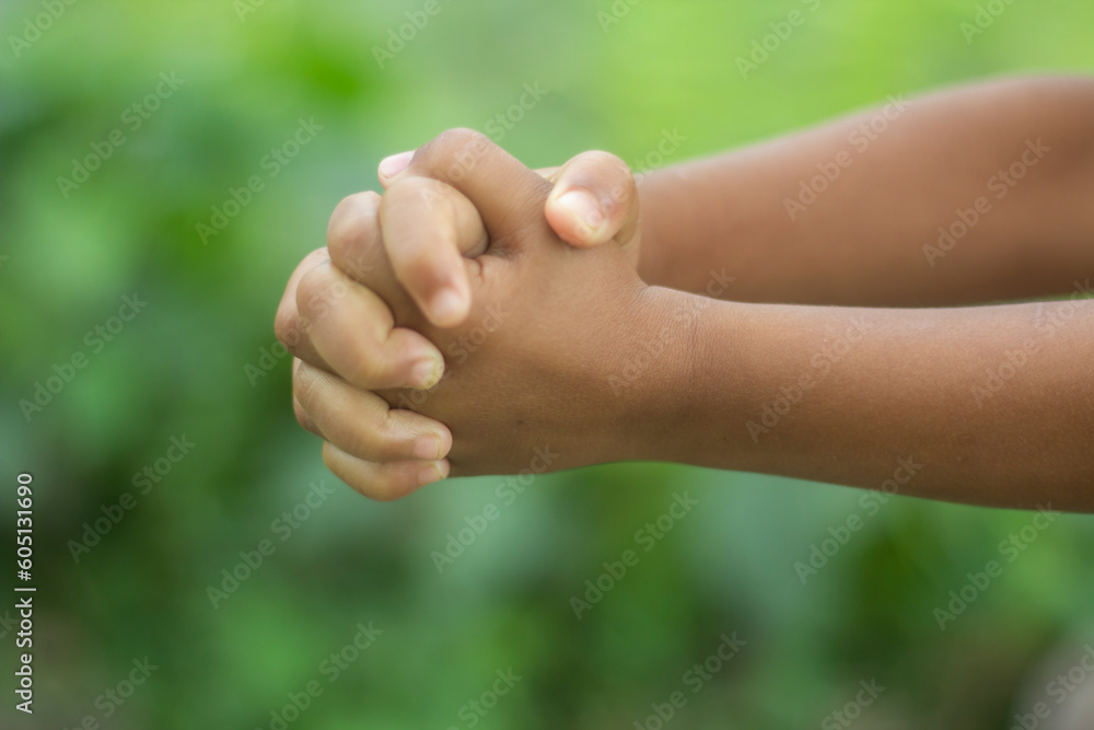 The two hands are in fists and the background is a green blur The two hands are in fists and the background is a green blur