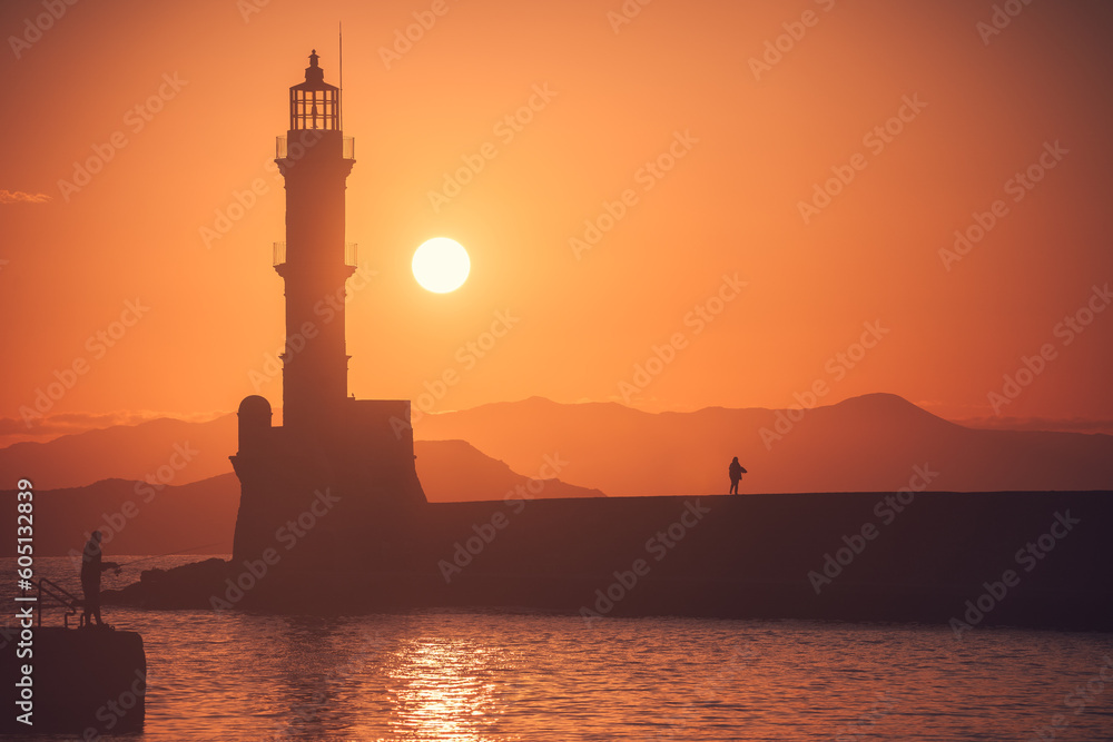 Greece's mesmerizing Chania: A breathtaking sunset and golden hour at the lighthouse in Crete; vibrant hues engulf the sky, illuminating the coastal beauty in a magical Greek setting