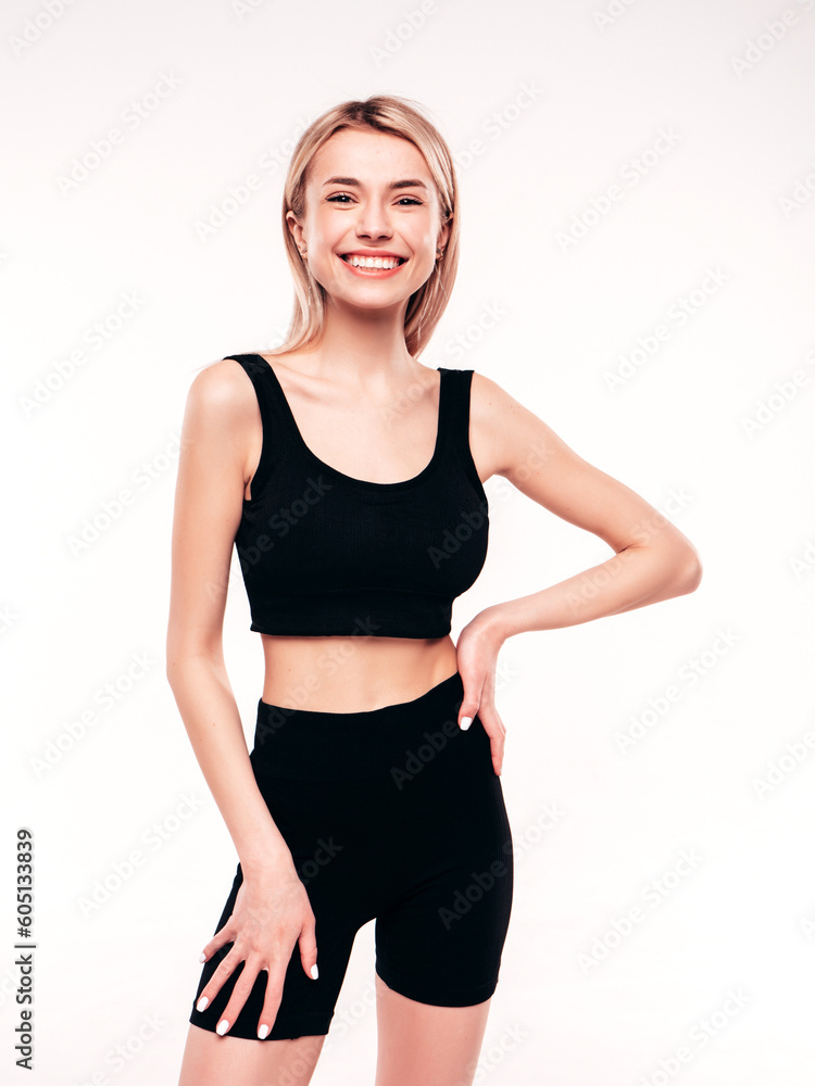 Young beautiful smiling blond female in summer black cycling shorts costume clothes. Sexy carefree woman posing on white in studio. Positive model having fun. Cheerful and happy Young beautiful smiling blond female in summer black cycling shorts costume clothes. Sexy carefree woman posing on white in studio. Positive model having fun. Cheerful and happy