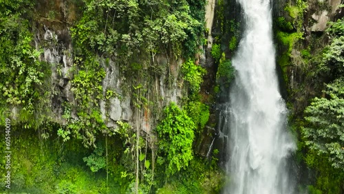 A tropical waterfall in a mountain canyon. Sikulikap Falls in slow motion. Sumatra, Indonesia. photo