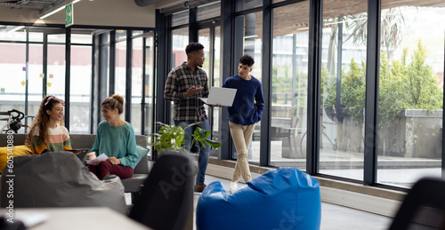 Busy diverse business people with laptop discussing work in office, unaltered