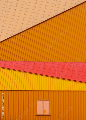 Abstract close-up photograph of a public building with orange and red tones and sharp lines