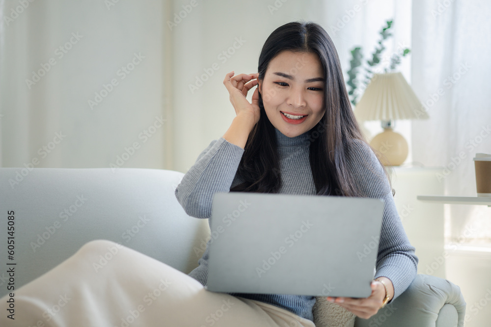 Woman plays on laptop on the sofa in her living room at home, she is resting on weekends after a hard day's work, she relaxes by watching movies and listening to music on her tablet. Holiday concept. Woman plays on laptop on the sofa in her living room at home, she is resting on weekends after a hard day's work, she relaxes by watching movies and listening to music on her tablet. Holiday concept.