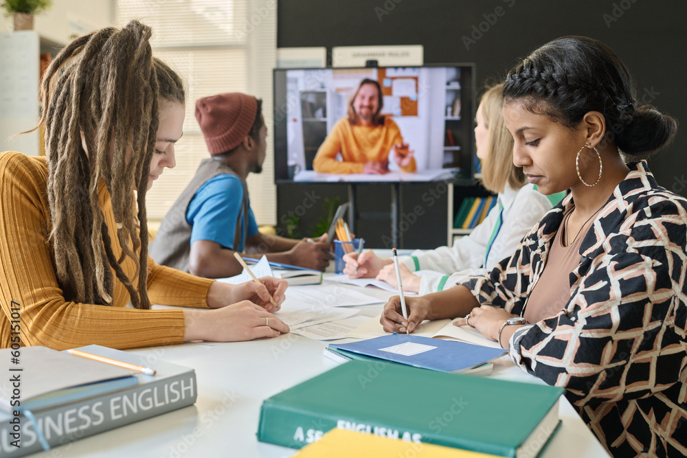 Naklejka premium Group of students having video call with teacher, they learning foreign languages with native speaker