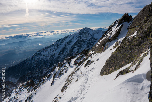 Dramatic, rocky, snowy mountain range, peaks with mist and clouds, High Tatras, Lomnicky Stit, Slovakia, European alps.