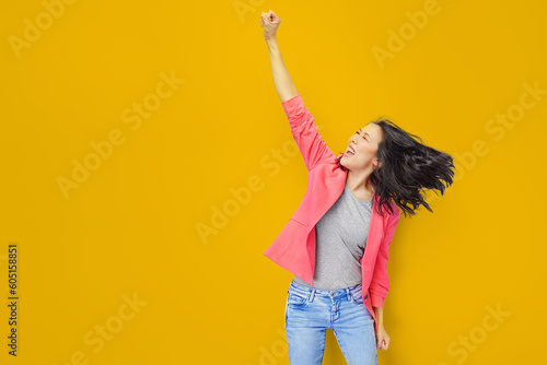 Photo of young attractive asian woman scream wear trendypink suit fists up hooray celebrate shopping season isolated on yellow color background. photo