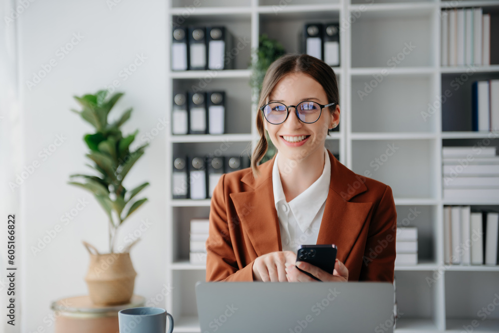 Confident business expert attractive smiling young woman typing laptop ang holding digital tablet on desk in creative office..