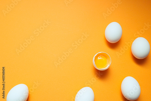 White eggs and egg yolk on the yellow background.