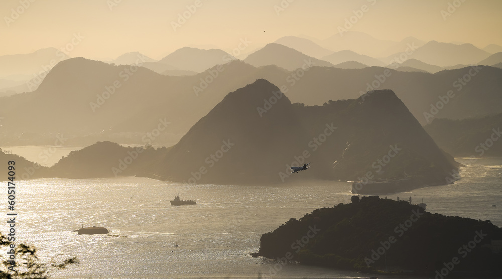 Airplane preparing to land on the Santos Dumont airport from Rio de Janeiro. Aerial photo with plane and the silhouettes of this mountain landscape in Brazil.