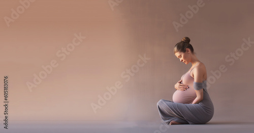 Young healthy pregnant woman doing yoga exercises and meditating at home. Health care, mindfulness, relaxation and wellness concept.  photo
