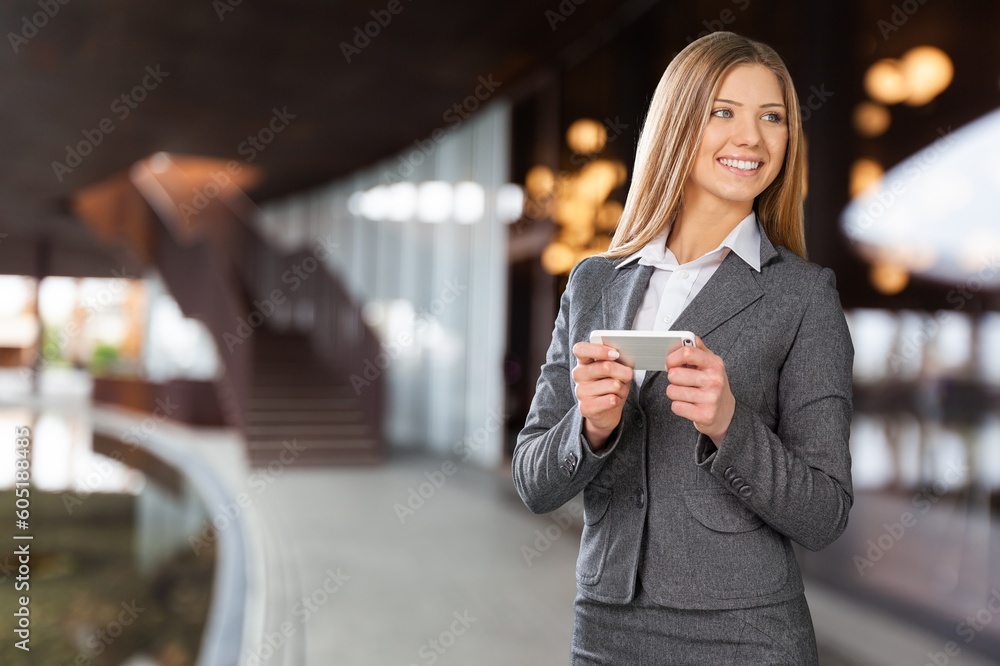 Portrait of a happy young woman posing outdoors, using smartphone. Portrait of a happy young woman posing outdoors, using smartphone.