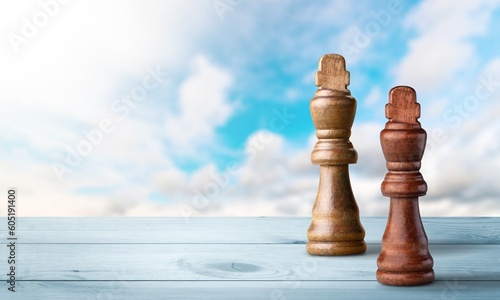 White and black classic chess figures on sky background
