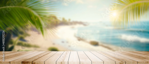 Empty wide Table top wooden bar with blurred beautiful beach scene background coconut leaf on frame for product display mockup outside summer day time. Resort clean wood desk board on nature view.
