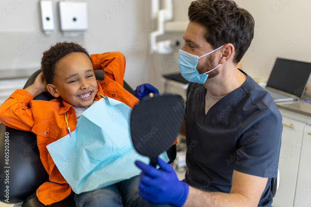 Dark-skinned boy talking to dentist before session Dark-skinned boy talking to dentist before session