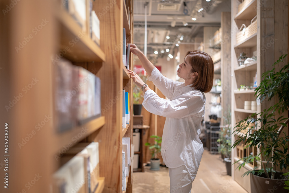 An asian woman in the bookstore.