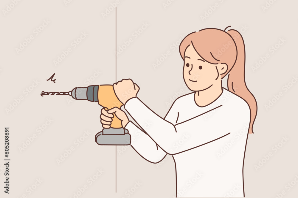 Woman uses electric drill to create hole in wall and hang shelf or picture in apartment Woman uses electric drill to create hole in wall and hang shelf or picture in apartment