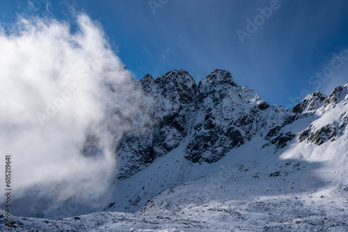 Panorama of Mountaineer standing on top of snowy mountain range at High Tatras, Slovakia © Martin