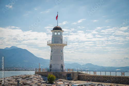 Lighthouse in the port of Alanya. white lighthouse in seaport of Alanya with concrete path and stones