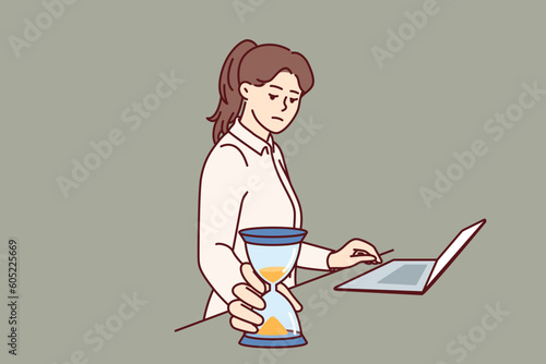Busy businesswoman with hourglass keeps track of time until deadline so as not to violate terms of important contract. Freelancer girl in business suit stands near laptop and does time management
