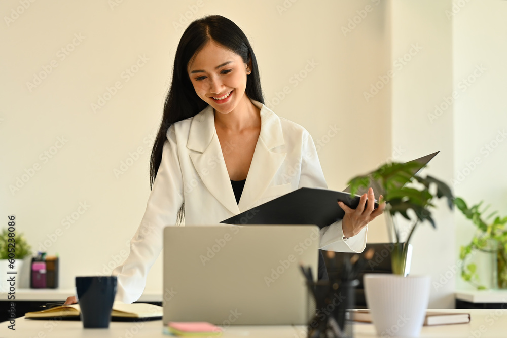 Confident female analyst in stylish suit watching online webinar on laptop screen. Business, communicating and technology Confident female analyst in stylish suit watching online webinar on laptop screen. Business, communicating and technology