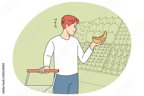 Smiling man choose fruit in supermarket