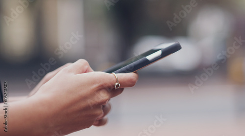 Woman, hands and searching phone with city background for texting message on social media. Female hand, typing and cellphone for research or writing messages for communication and connection.