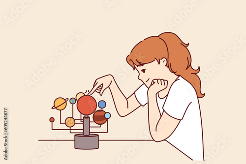 Little girl is studying solar system and location of planets in space, wanting to become astronomer. Schoolgirl teenager with visual aid for teaching children astronomy and science space exploration