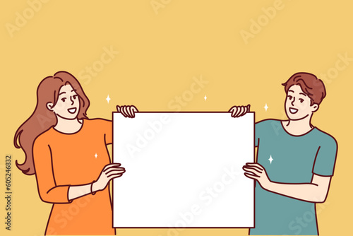 Happy couple with blank poster with copy space for your promotional offer or company logo. Man and woman show blank poster for application of information with announcement of favorable discounts